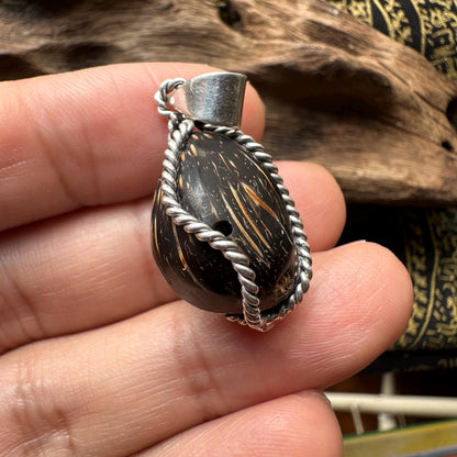 Coconut Pearl centipede pendant held in hand