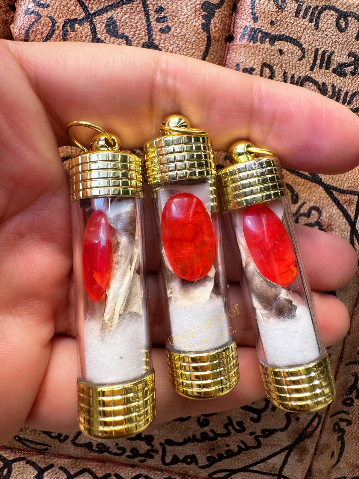 Red Nagamani pendant held in hand for size reference