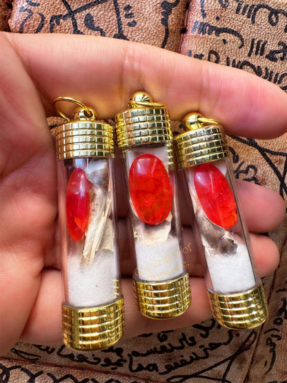 Red Nagamani pendant held in hand for size reference