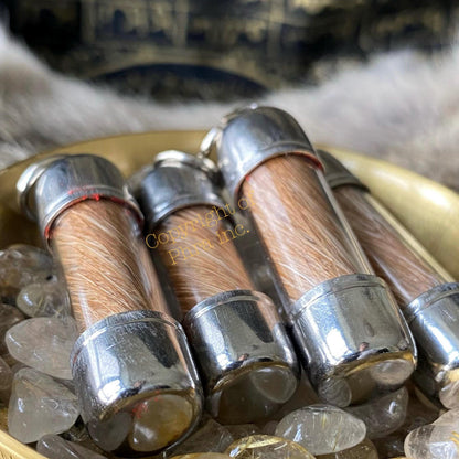 Moroccan hyena scroll amulet held in hand for scale