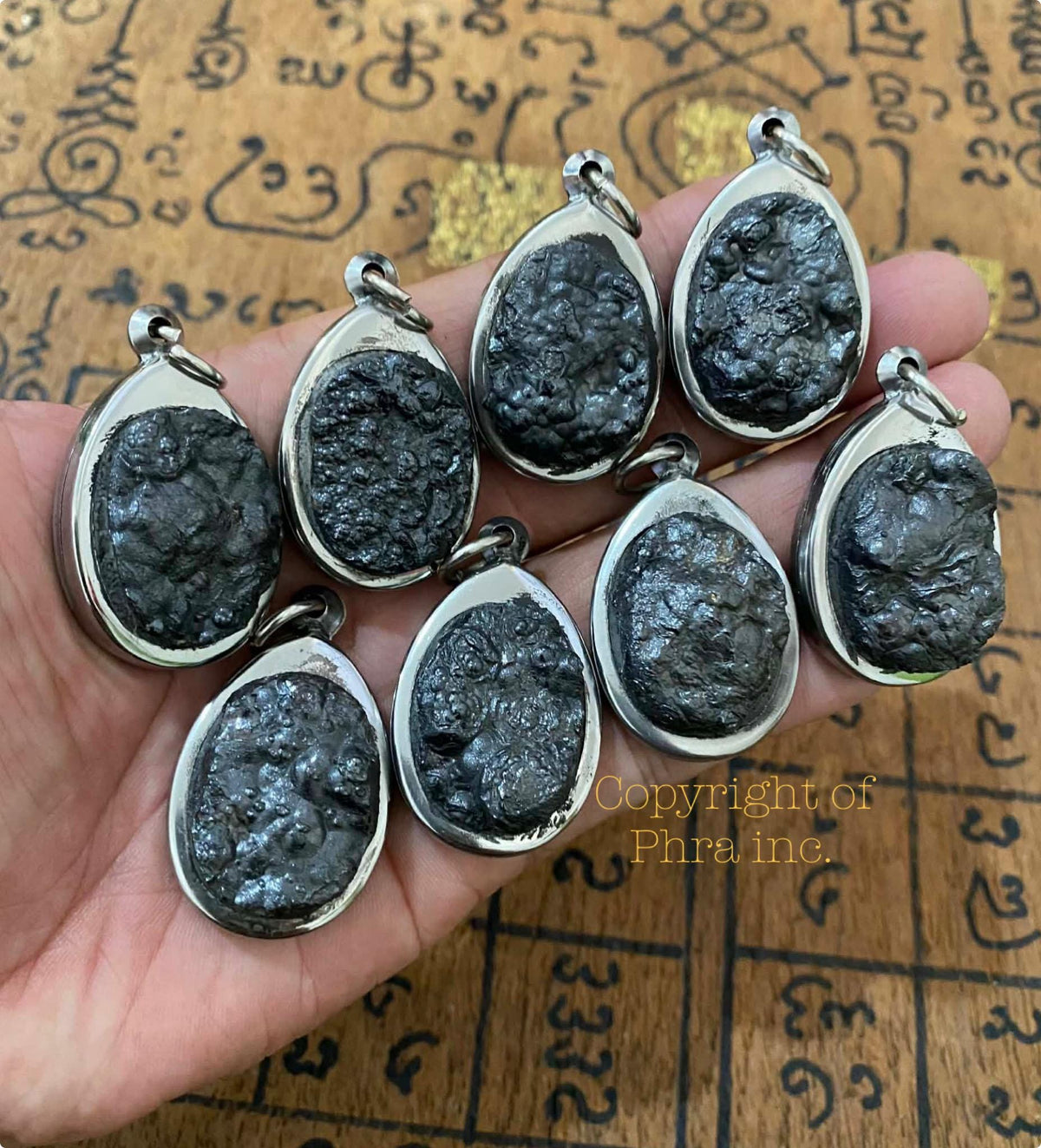 Leklai Tarad pendant held in hand for scale