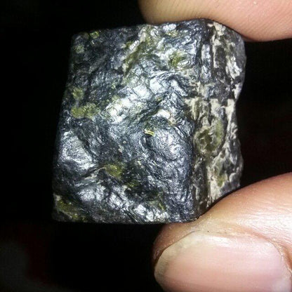 White Lightning Stone amulet held in hand for scale