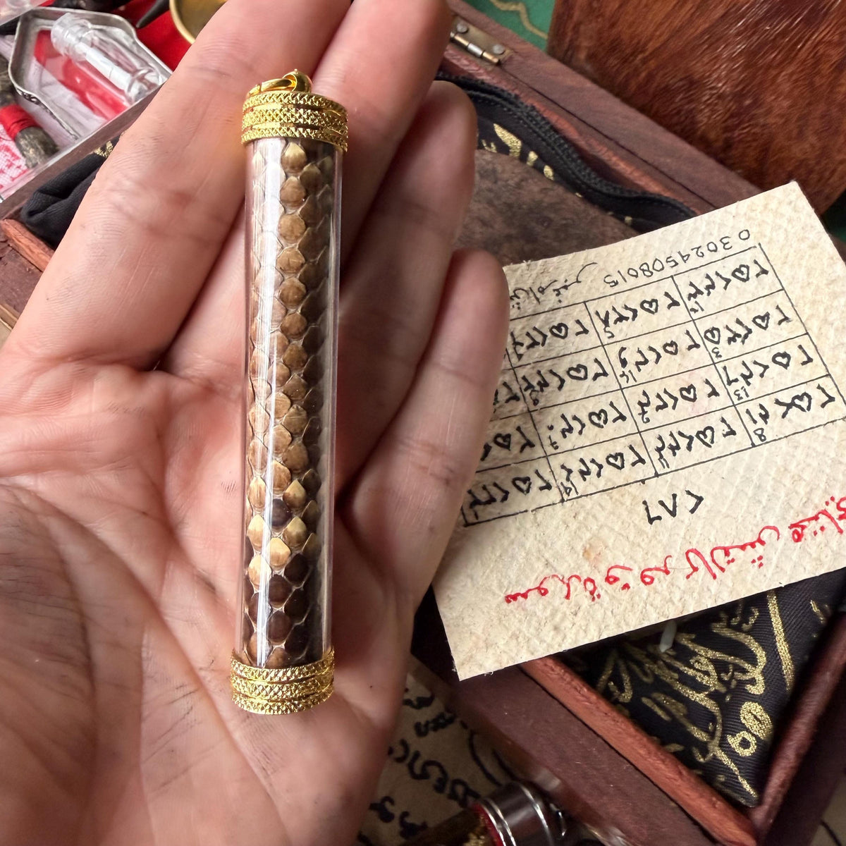 Hand-drawn inscriptions on the python skin taweez, close-up