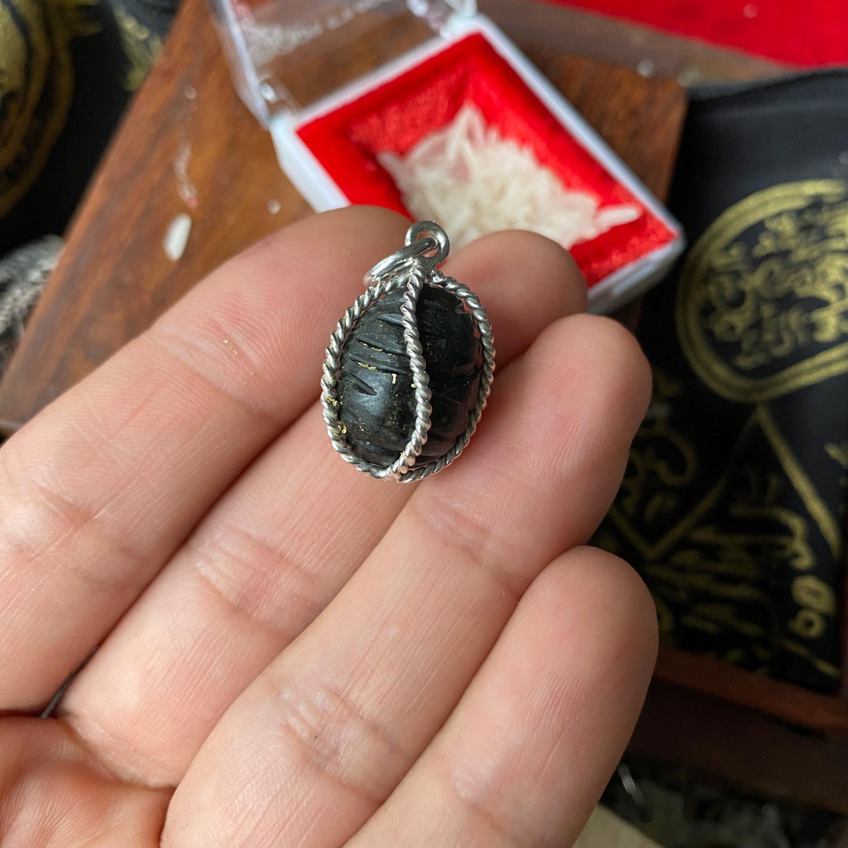 Crow bezoar silver pendant shown from the side