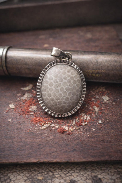 White Nagamani pendant shown from the side