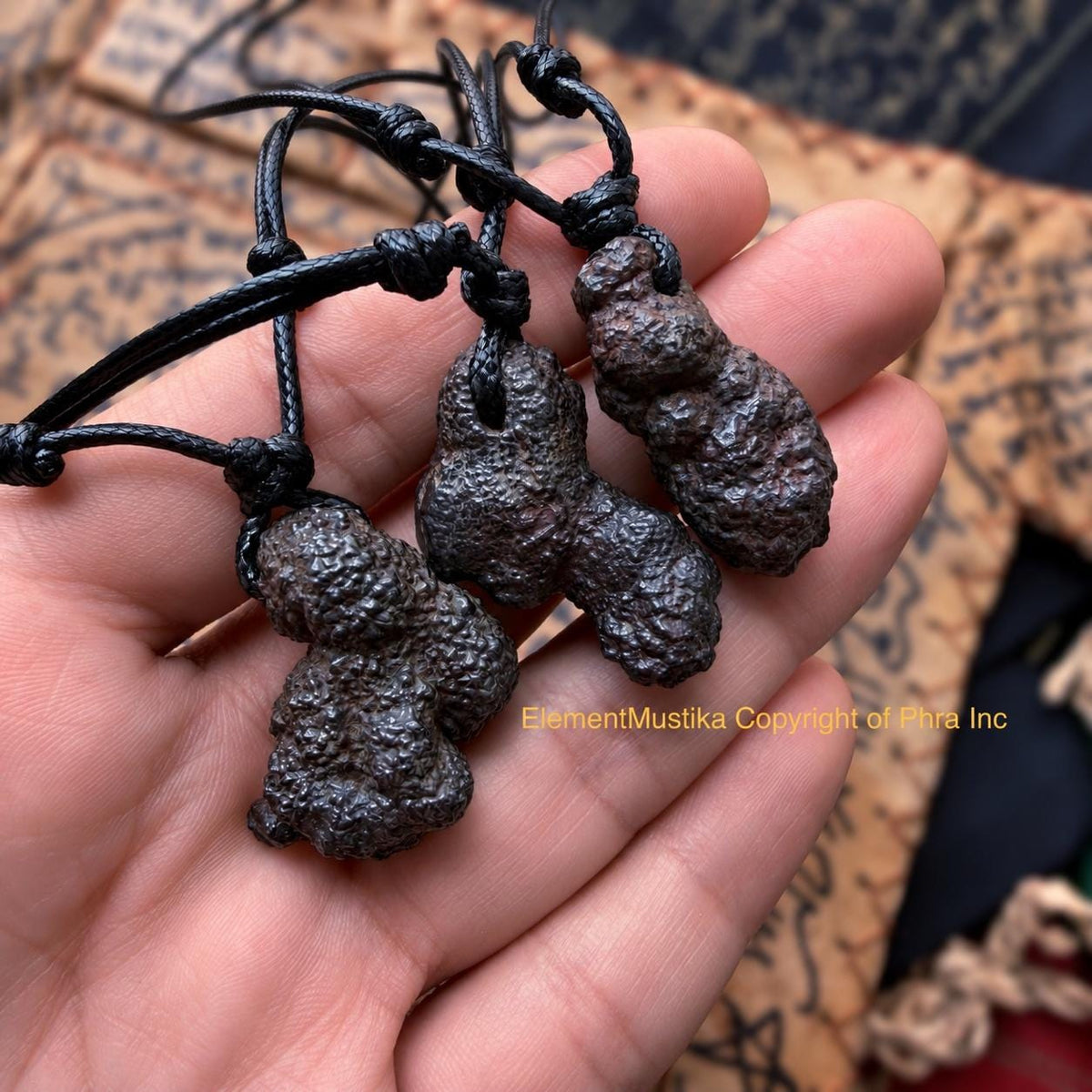 Munta Besi stone pendant held in hand for scale